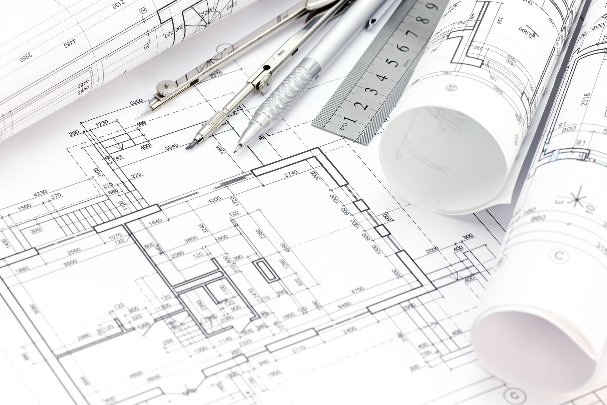 architect workspace with floor plan, blueprint rolls, drawing tools